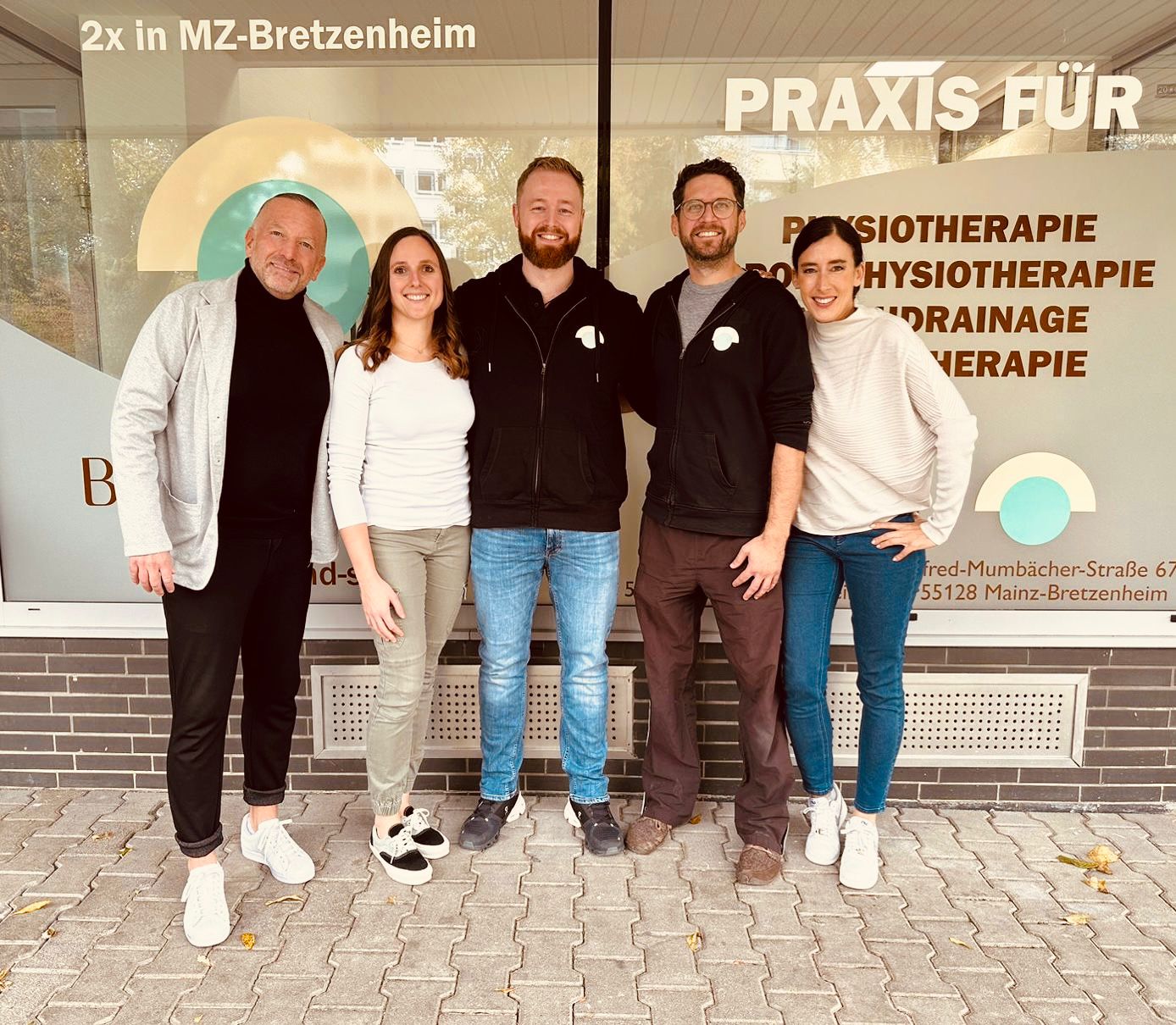 Gruppenbild der Mitarbeiter und der Geschäftsführung vor den neuen Praxisräumen in Mainz-Bretzenheim